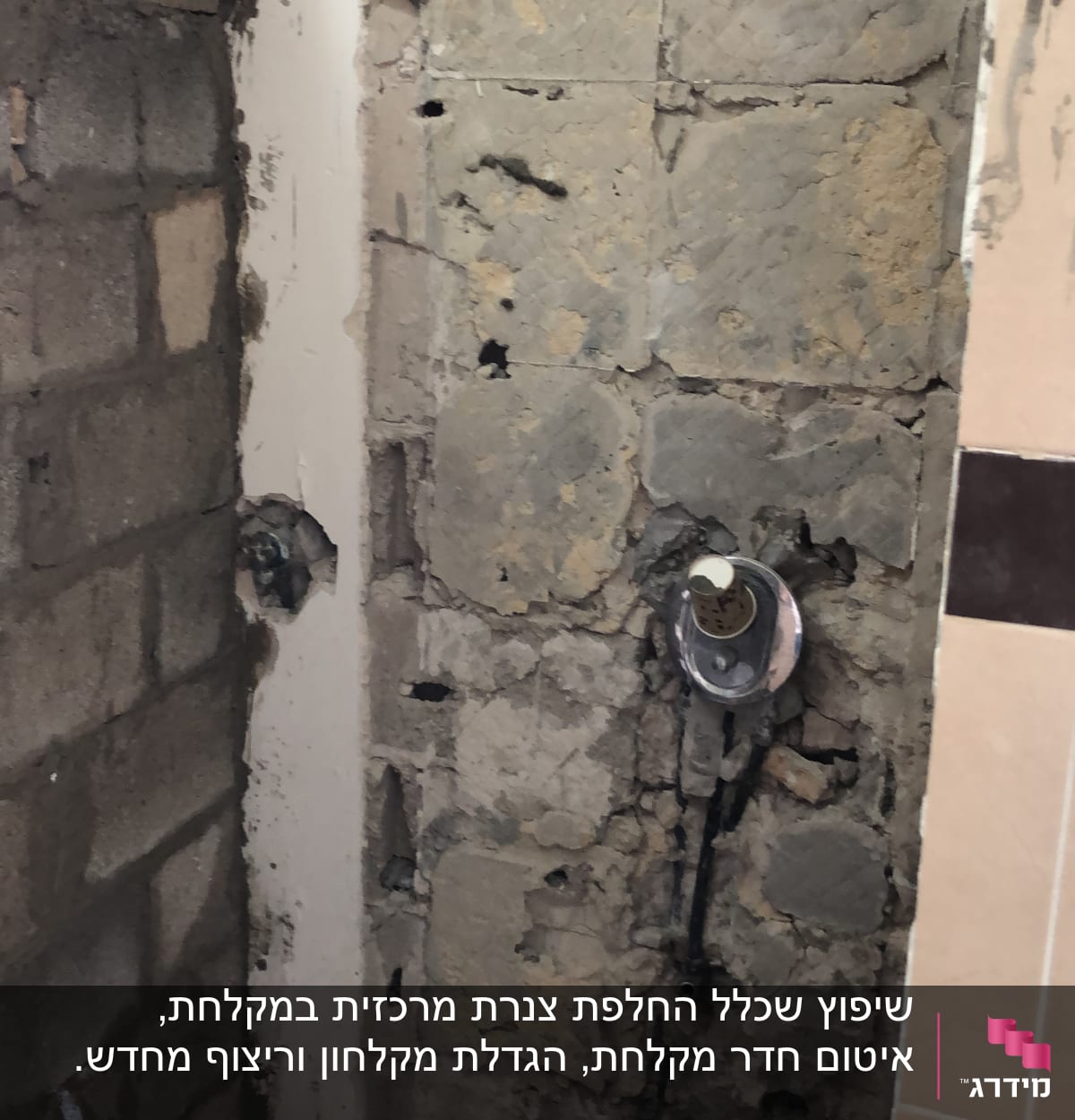 קיר חשוף עם צנרת חשמל ושקע במהלך שיפוץ